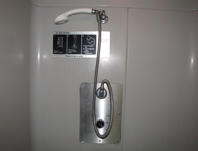 The inside of a shower on the train. The shower head is removable, for handicapped individuals.