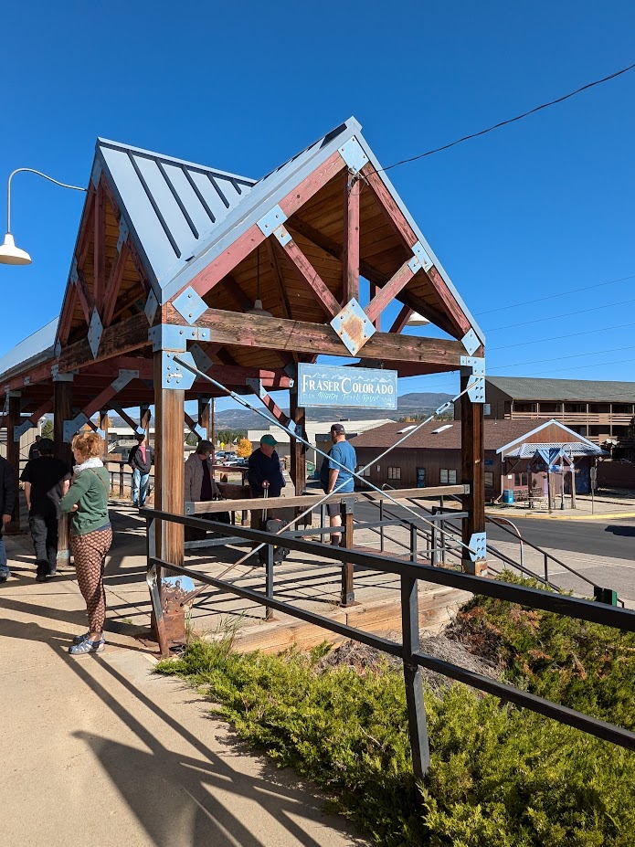 The Fraser/Winter Park Station in Colorado. Many people on the platform, and it is a bright sunny day.